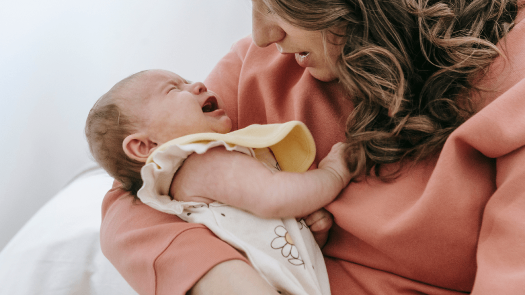 baby crying in mother's arm